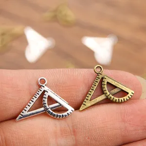 Close-up view of the metal ruler charms, showing fine scale details and dual color options.