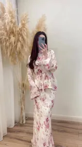 Detail view of the elegant floral two-piece outfit featuring long sleeves and skirt.