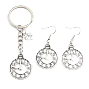 Vintage pocket watch keychain and matching earrings detail, retro steampunk alloy jewelry set.
