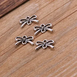 Detail view of silver bow metal charms, DIY jewelry connectors for bracelets and necklaces.