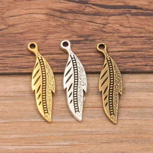 Close-up of 3-color metal alloy feather leaf pendants, ideal for DIY jewelry making and crafts.