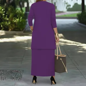 Detailed view of solid purple long sleeve coat and skirt set in outdoor street scene.