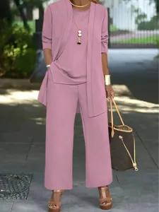 Women's 3-piece pantsuit detail showing elegant pink cardigan, top and wide-leg trousers.