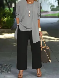 Detail shot of casual three-piece outfit featuring grey top and black wide leg pants.