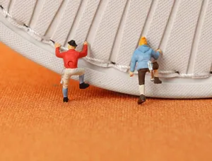 Close-up detail of winter cotton slippers non-slip rubber sole with miniature climbing figures.