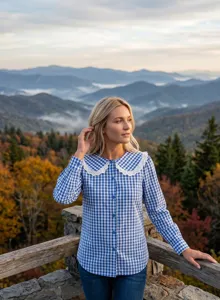 Vue de détail de la jolie chemise féminine à carreaux bleus avec beau col poupée en dentelle.