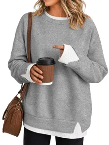 Dettaglio della felpa girocollo color block da donna, maniche lunghe oversize con polsini bianchi.