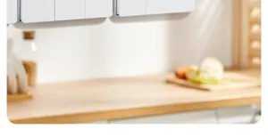 Gros plan d'un panneau d'interrupteur mural blanc sous le meuble de cuisine dans un intérieur moderne.
