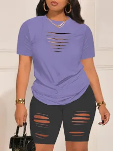 Close-up of stylish cut-out short sleeve t-shirt and biker shorts set with chic details.