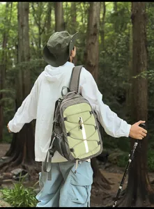 Outdoor hiking scene detail of the green color-matching patchwork backpack in forest.