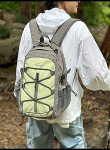 Outdoor hiking backpack detail showing green contrast color, bungee cord, and mesh side pocket.