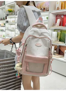 Detailansicht des rosa-weißen Schulrucksacks mit Sternenmuster, transparenter Tasche und Anhänger.