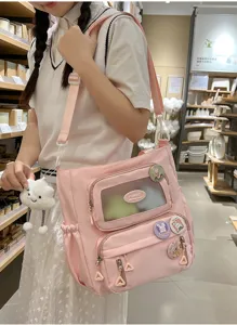 Rosa Umhängetasche Itabag mit transparenter Tasche und niedlichen Abzeichen Details.