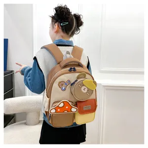 Vue détaillée du mini sac à dos marron pour enfants, avec adorables poches ours et champignon.