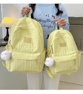 Joli sac à dos décontracté jaune avec pendentif en peluche, idéal pour école et voyage.