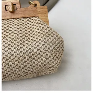 Detailansicht der Sommer Stroh gewebten Handtasche mit Holzverschluss und natuerlicher Textur.