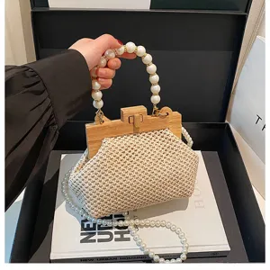 Detailansicht der gewebten Strohtasche für Damen mit Perlenhenkel und Holzverschluss.