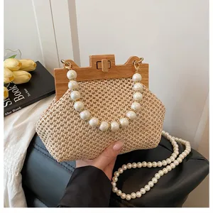 Schicke Stroh Handtasche mit Holzverschluss und Perlenhenkel Details für Sommer Strand Urlaub.