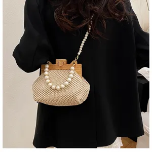 Elegante geflochtene Strohtasche mit Holzverschluss und Perlenkette für Sommer.