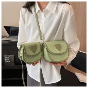 Grüne Umhängetasche mit Herz-Aufnäher im Detail, trendige Damen Handtasche für den Alltag.