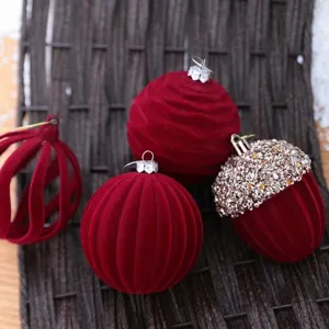 Vista detallada de bolas de Navidad de terciopelo rojo oscuro con flocado y lentejuelas.