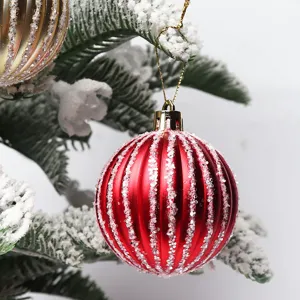 Dettaglio della pallina di Natale a righe rosse appesa al ramo dell'albero di Natale.