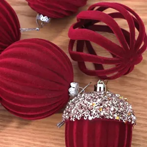 Primer plano detallado de bolas de navidad de terciopelo rojo, esferas huecas y decoraciones.