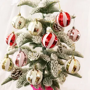 Primer plano de bolas de Navidad coloridas y a rayas con un hermoso árbol flocado.