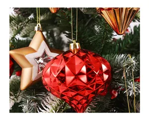 Vista detallada de adornos colgantes para árbol de navidad de estrella dorada y diamante rojo.