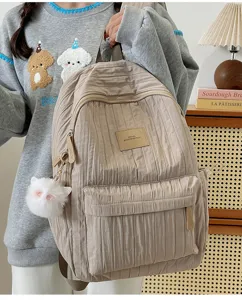 Vue détaillée du sac à dos plissé décontracté, montrant la texture et le joli pendentif.