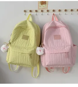 Vue détaillée de jolis sacs à dos d'étudiant avec pendentif en peluche et poche avant.