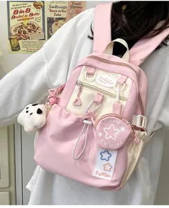 Primo piano dettagliato dello zaino rosa carino con ciondoli, spallacci e tasche pratiche.