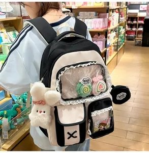 Süßer farbblockierter Studentenrucksack mit transparenter Tasche und niedlichen Plüschanhängern.