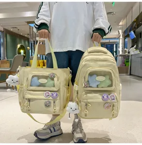 Niedliches gelbes Ita-Rucksack-Set mit Sichtfenster, Kissen und süssen Pins für die Schule.