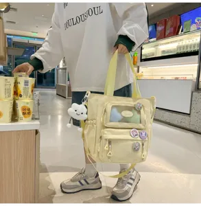 Detailansicht der gelben Canvas-Schultasche mit transparentem Sichtfenster und Taschen.