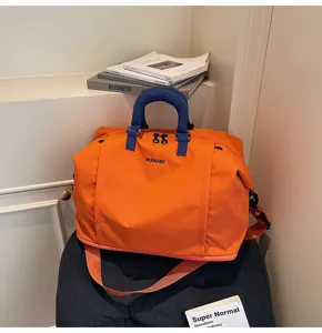 Vue détaillée du sac de voyage orange avec poignées bleues pour courts séjours et usage.