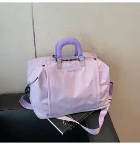 Vue détaillée du grand sac de voyage violet clair avec poignées épaisses et bandoulière.