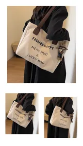 Detailansicht der großen beigen Segeltuchtasche mit braunen Schultergurten und süßem Bärenanhänger.
