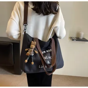 Schwarze Canvas Shopper Tasche mit braunen Riemen, coolem Aufdruck und Kaninchen Anhänger.