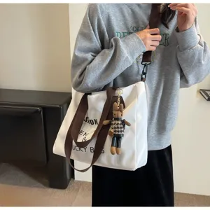 Große Canvas Tragetasche für Damen mit braunen Schultergurten und süßem Hasenanhänger.