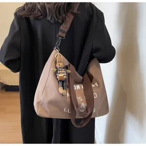 Detailansicht der lässigen Canvas Schultertasche mit verstellbarem Gurt und Kaninchenanhänger.
