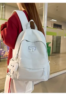 Lässiger hellgrauer Schülerrucksack Detail mit Fronttasche und plüschiger Deko.