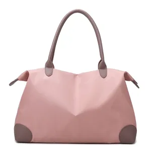 Large capacity travel duffel bag, pink weekender bag with brown handles for women and trips.