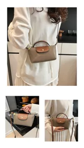 Detailaufnahme der kleinen Nylon-Falttasche mit brauner Lederlasche und Schulterriemen.