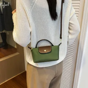 Grüne Nylon Mini Umhängetasche mit brauner Lederklappe und praktischem Tragegriff.
