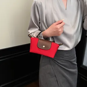 Nahaufnahme Detail der roten Mini Nylon Handtasche mit klassischem braunen Lederklappdeckel.
