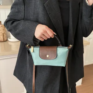 Schicke Mini Nylon Handtasche mit Lederklappe als elegante Umhängetasche für Damen.