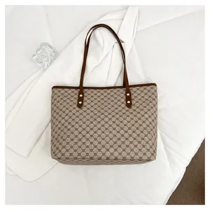 Detail view of the elegant brown monogram tote bag, featuring classic pattern and durable handles.
