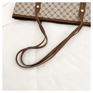 Detail view of women's tote shoulder bag showing classic monogram pattern and leather straps.