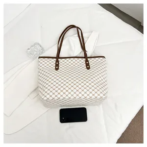 Women's large capacity canvas tote bag with brown leather handles and chic geometric pattern for daily commute.